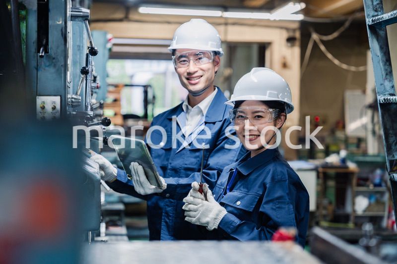 タブレット端末を確認しながら働く技術スタッフ