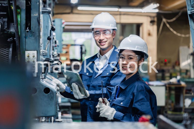 タブレット端末を確認しながら働く技術スタッフ