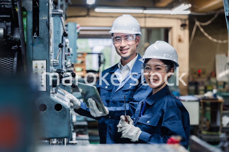 タブレット端末を確認しながら働く技術スタッフ