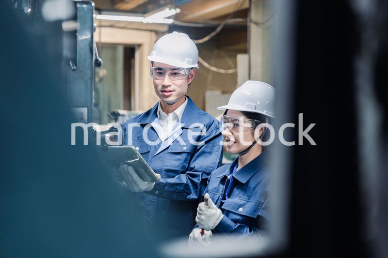 タブレット端末を確認しながら働く技術スタッフ