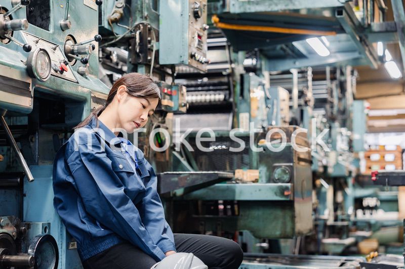 過労でやる気をなくす工場労働者の女性