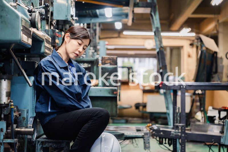 過労でやる気をなくす工場労働者の女性
