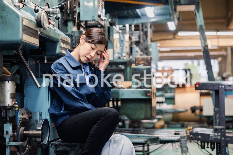 過労でやる気をなくす工場労働者の女性