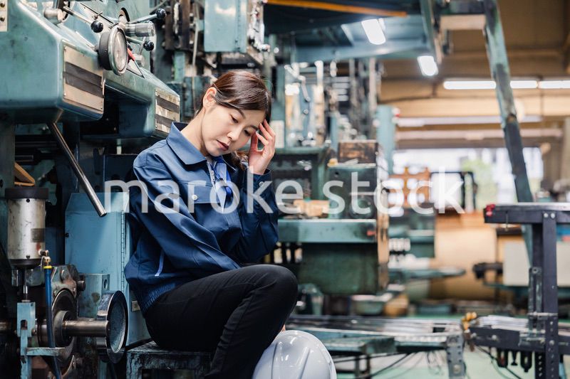 過労でやる気をなくす工場労働者の女性