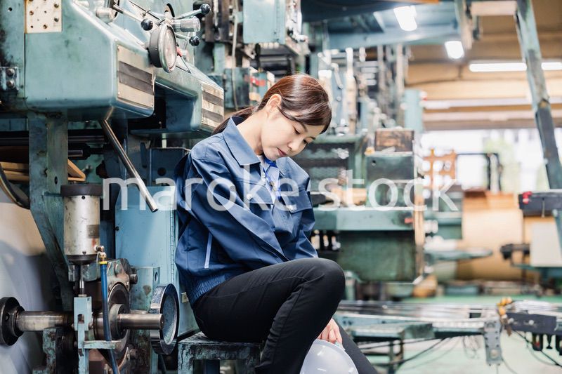 過労でやる気をなくす工場労働者の女性