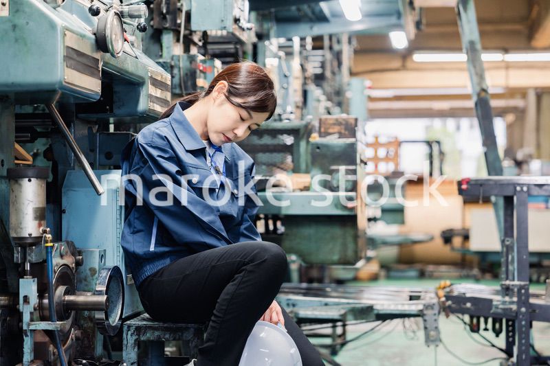 過労でやる気をなくす工場労働者の女性