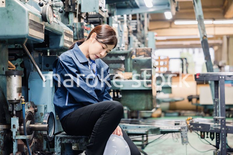 過労でやる気をなくす工場労働者の女性