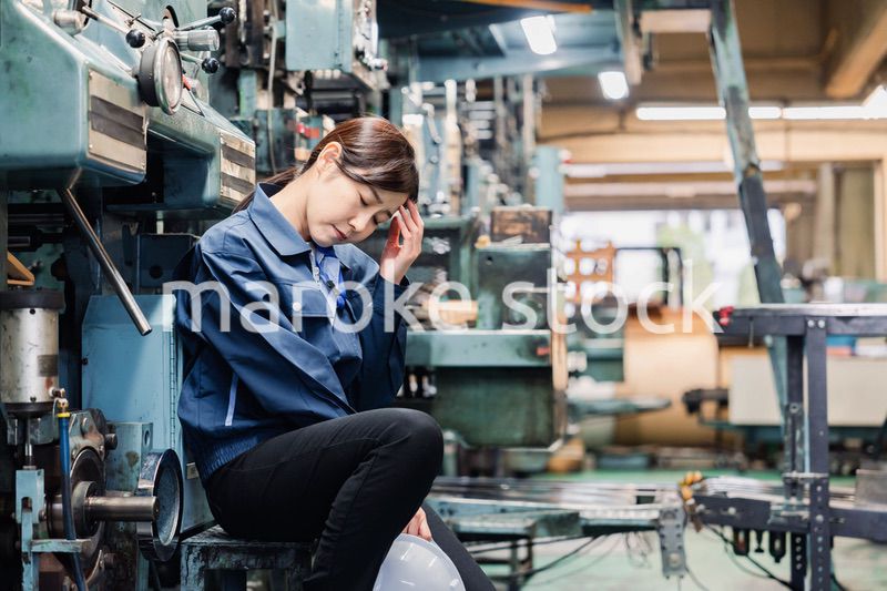 過労でやる気をなくす工場労働者の女性