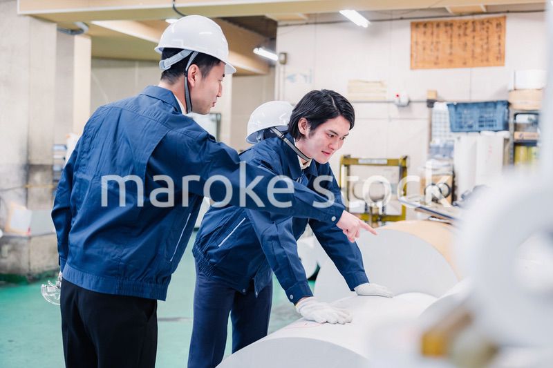 印刷工場でロール紙の確認をする作業員