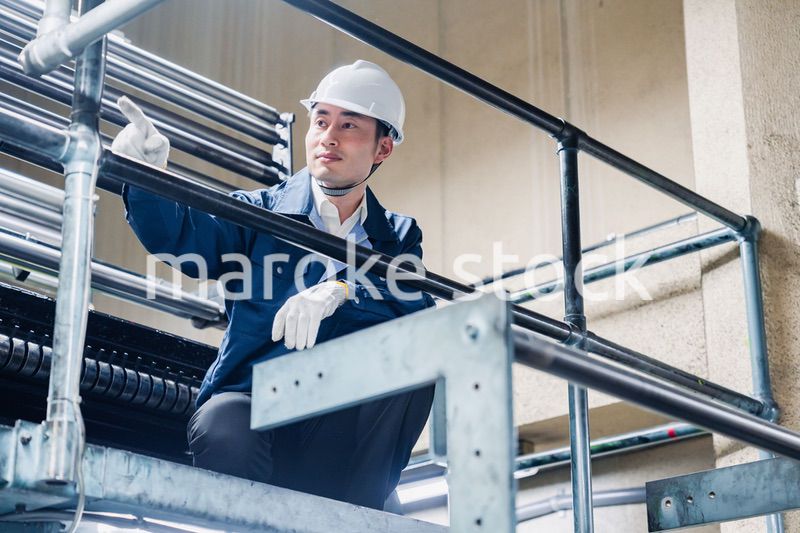 足場で高所作業をする男性作業員