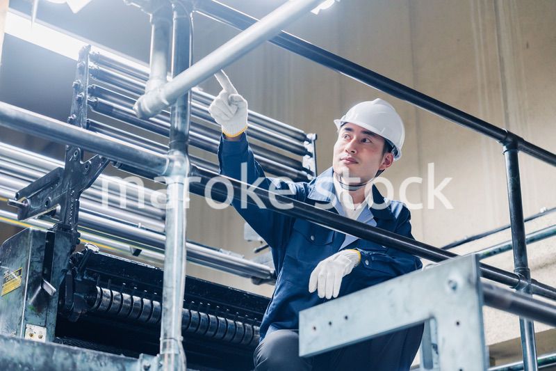 足場で高所作業をする男性作業員