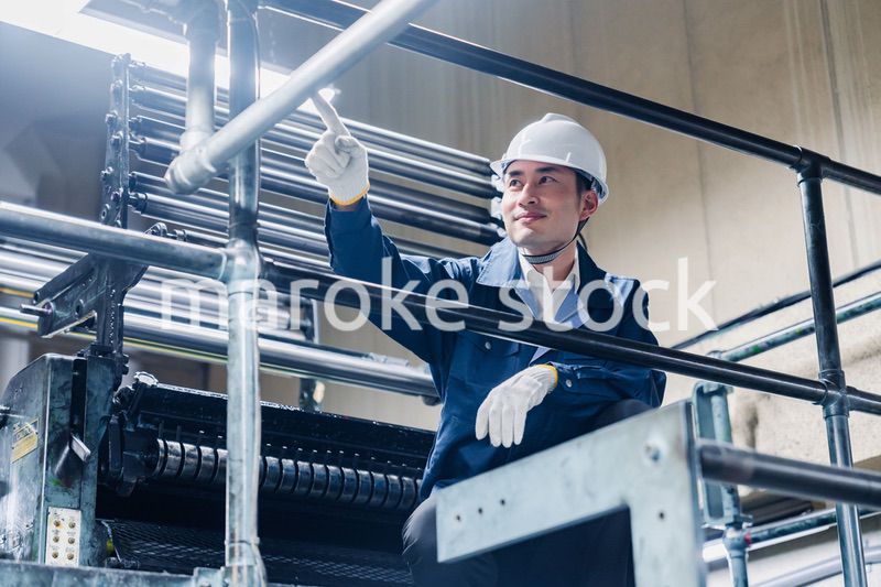 足場で高所作業をする男性作業員
