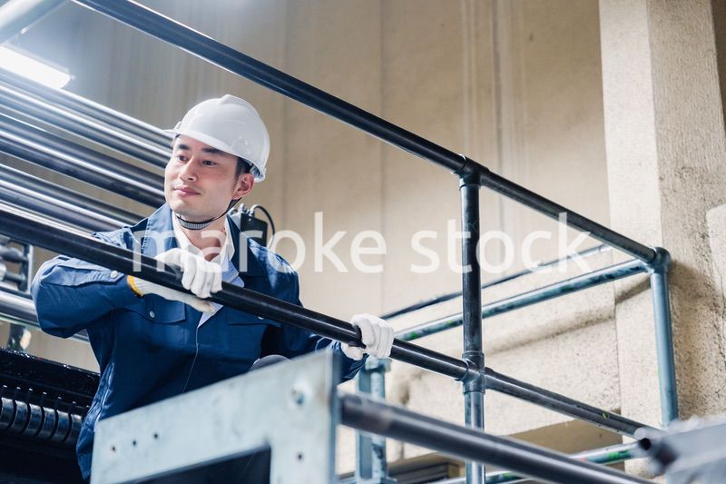 足場で高所作業をする男性作業員