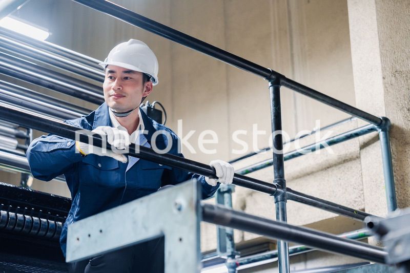 足場で高所作業をする男性作業員
