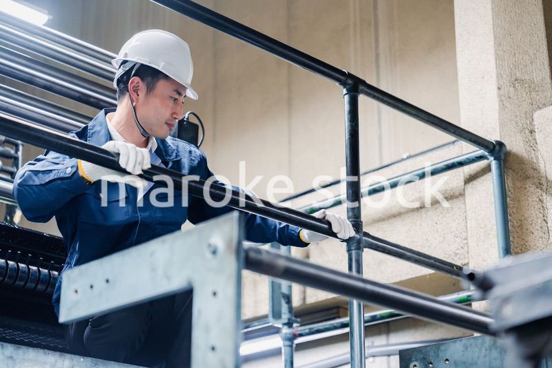 足場で高所作業をする男性作業員