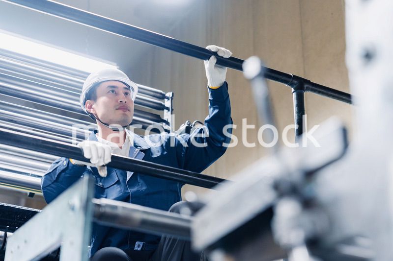 足場で高所作業をする男性作業員