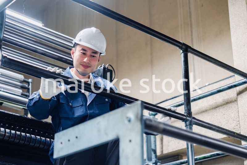 足場で高所作業をする男性作業員