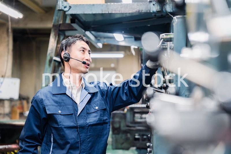 ヘッドセットをつけて重機を操作する男性作業員