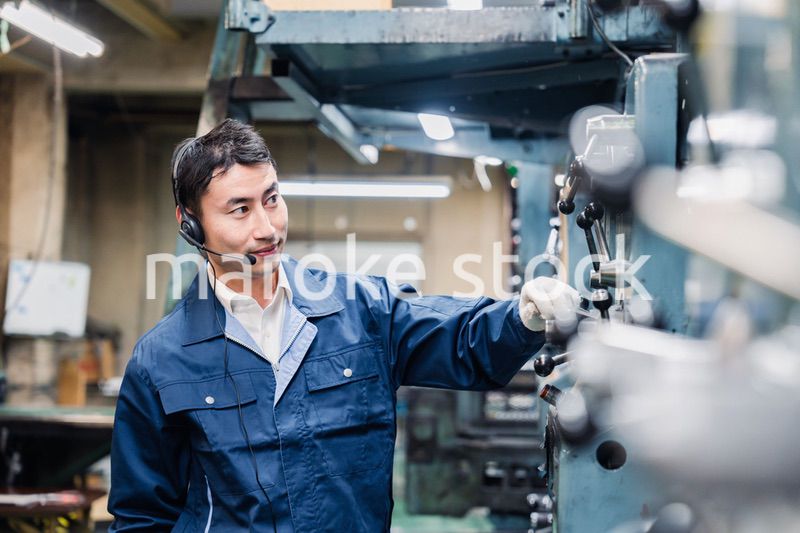 ヘッドセットをつけて重機を操作する男性作業員