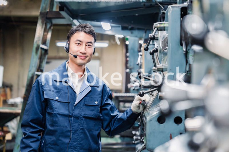 ヘッドセットをつけて重機を操作する男性作業員