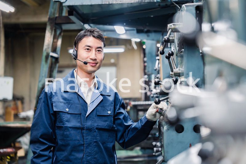 ヘッドセットをつけて重機を操作する男性作業員