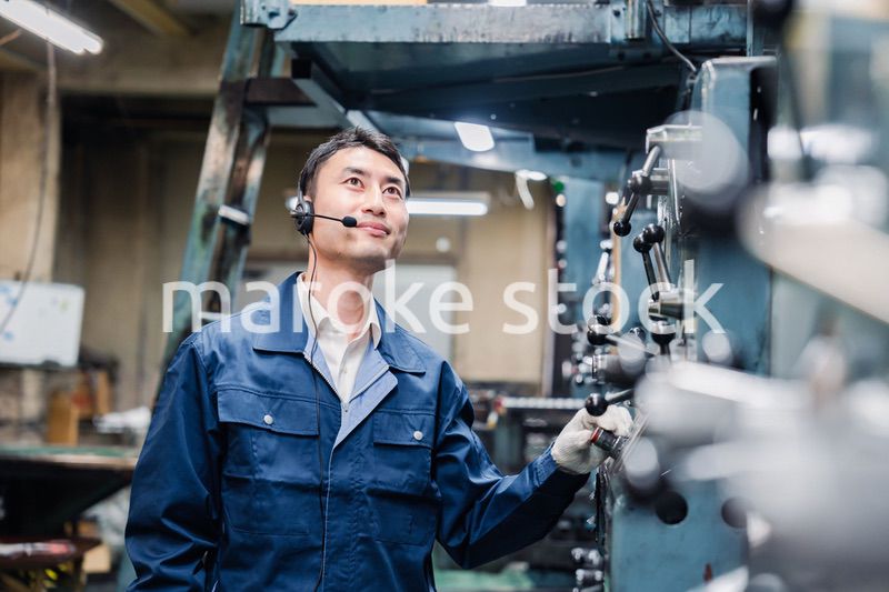 ヘッドセットをつけて重機を操作する男性作業員