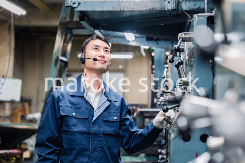 ヘッドセットをつけて重機を操作する男性作業員