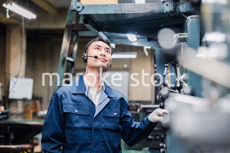 ヘッドセットをつけて重機を操作する男性作業員