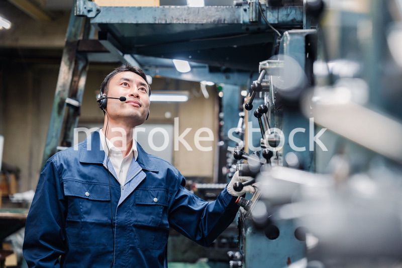 ヘッドセットをつけて重機を操作する男性作業員