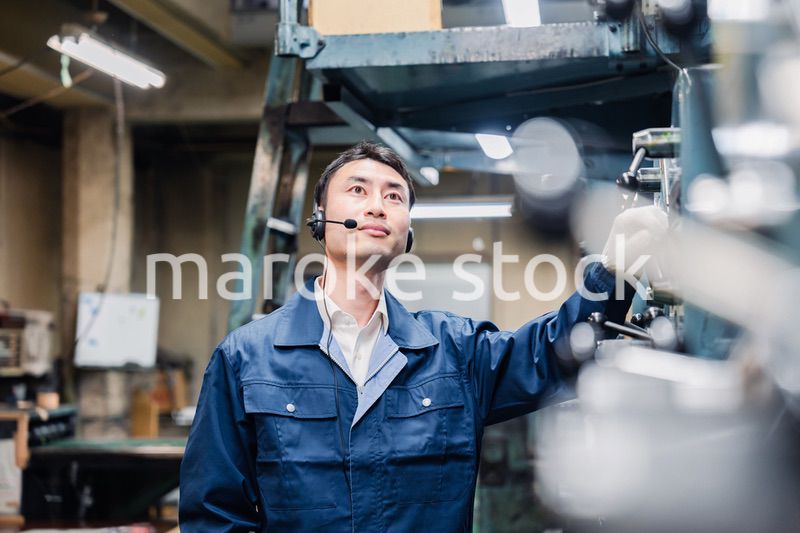 ヘッドセットをつけて重機を操作する男性作業員