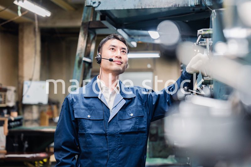 ヘッドセットをつけて重機を操作する男性作業員