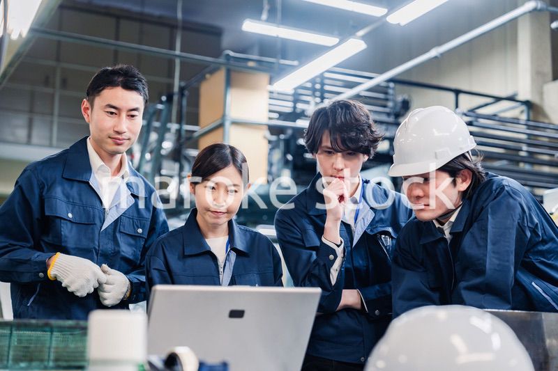 パソコンを見ながら議論をする工場スタッフ