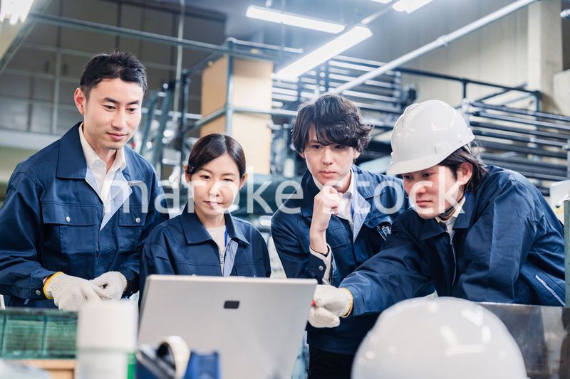 パソコンを見ながら議論をする工場スタッフ