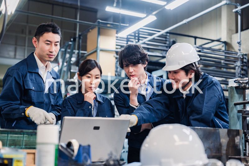 パソコンを見ながら議論をする工場スタッフ