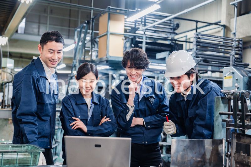 パソコンを見ながら議論をする工場スタッフ