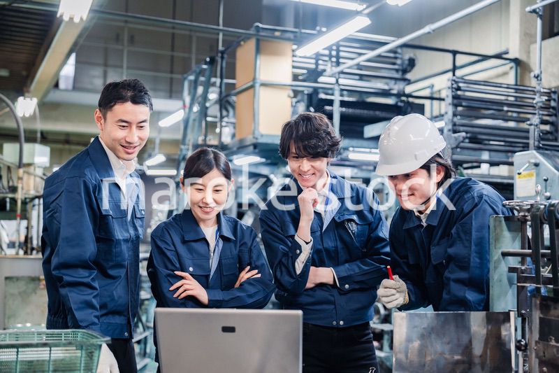 パソコンを見ながら議論をする工場スタッフ
