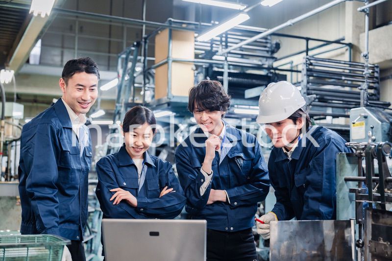パソコンを見ながら議論をする工場スタッフ