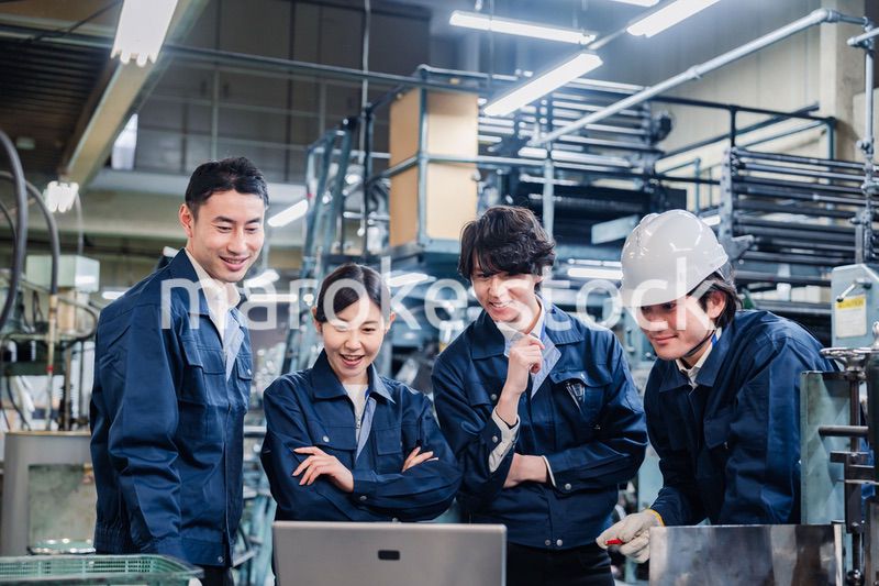 パソコンを見ながら議論をする工場スタッフ