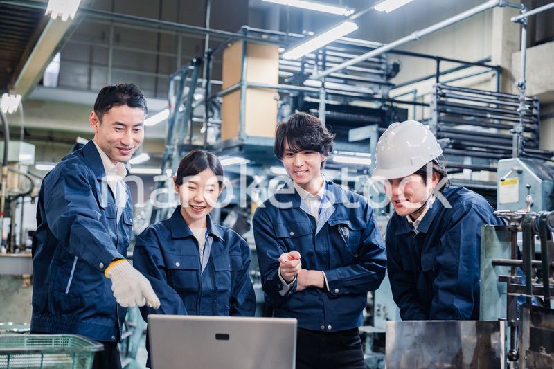 パソコンを見ながら議論をする工場スタッフ