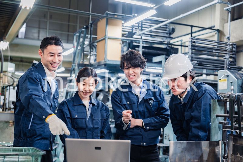 パソコンを見ながら議論をする工場スタッフ