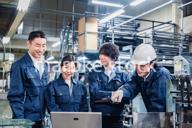 パソコンを見ながら議論をする工場スタッフ