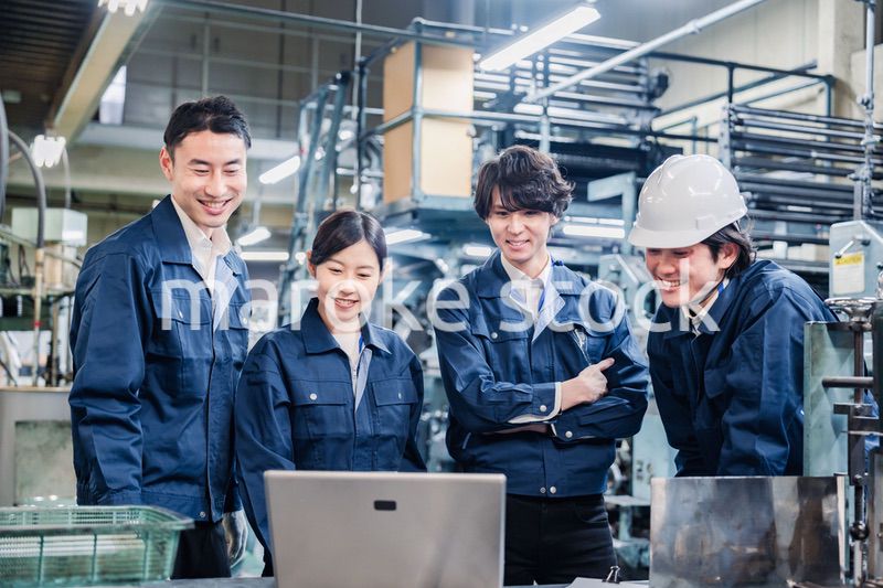 パソコンを見ながら議論をする工場スタッフ