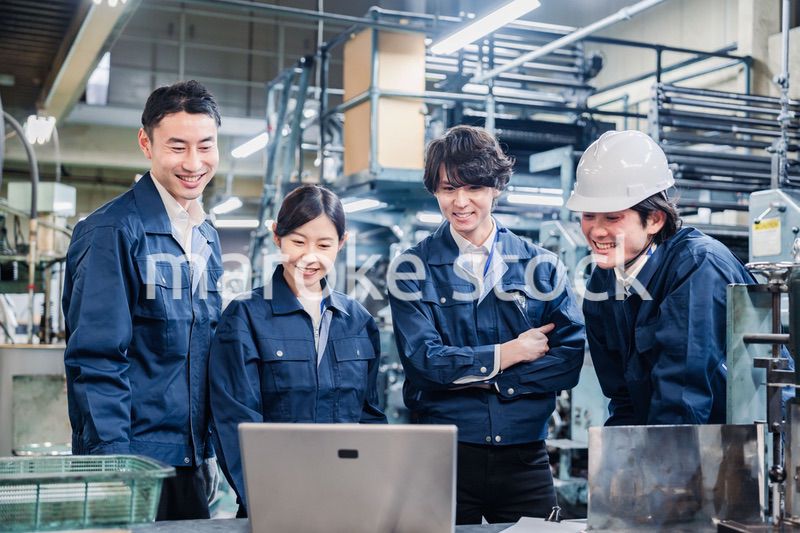 パソコンを見ながら議論をする工場スタッフ