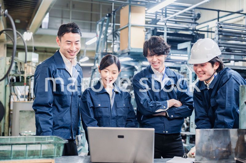 パソコンを見ながら議論をする工場スタッフ