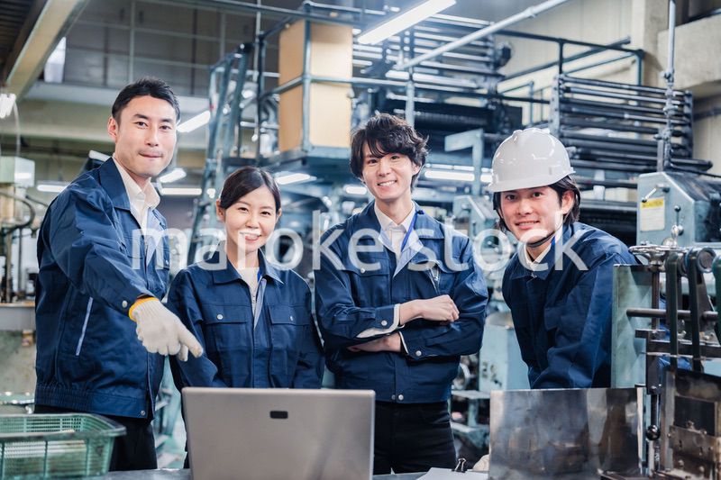 パソコンを見ながら議論をする工場スタッフ