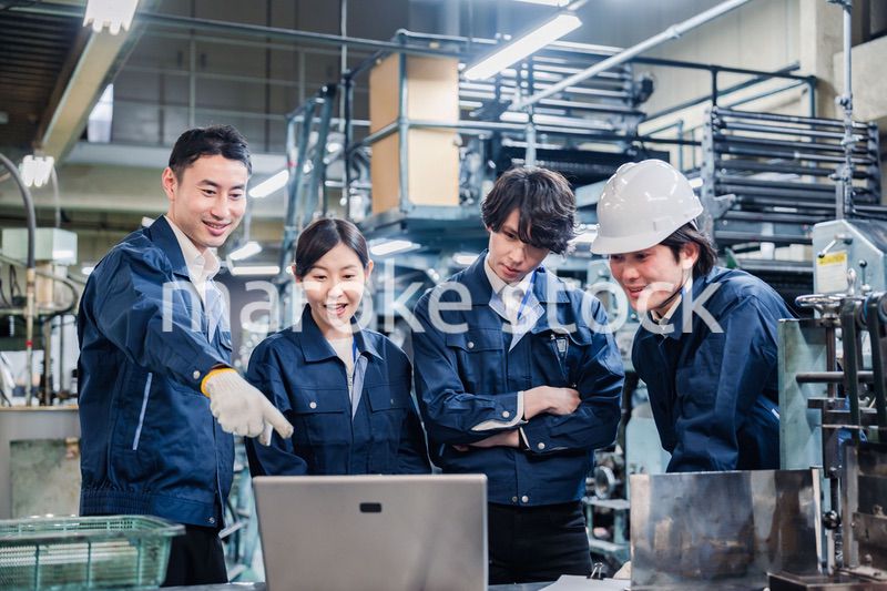 パソコンを見ながら議論をする工場スタッフ