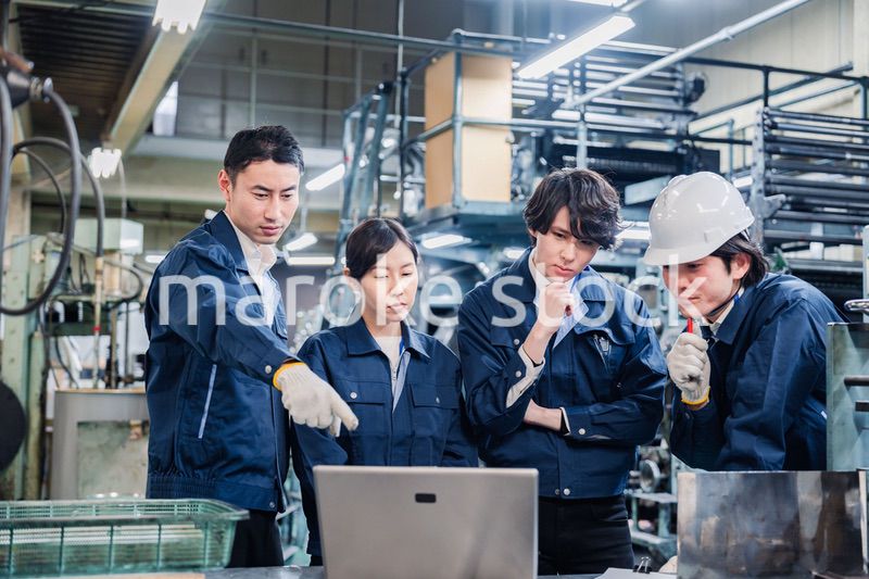 パソコンを見ながら議論をする工場スタッフ
