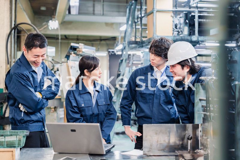 パソコンを見ながら議論をする工場スタッフ