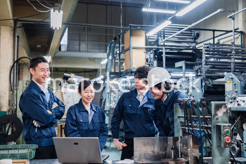 パソコンを見ながら議論をする工場スタッフ