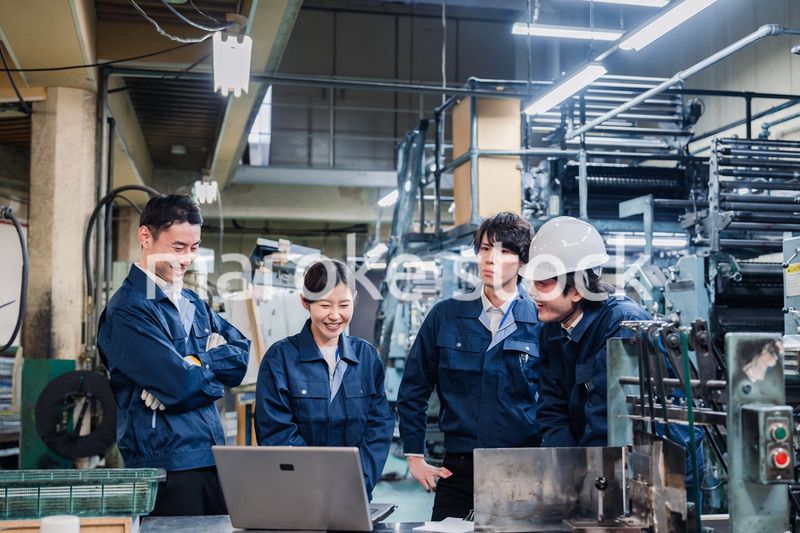 パソコンを見ながら議論をする工場スタッフ
